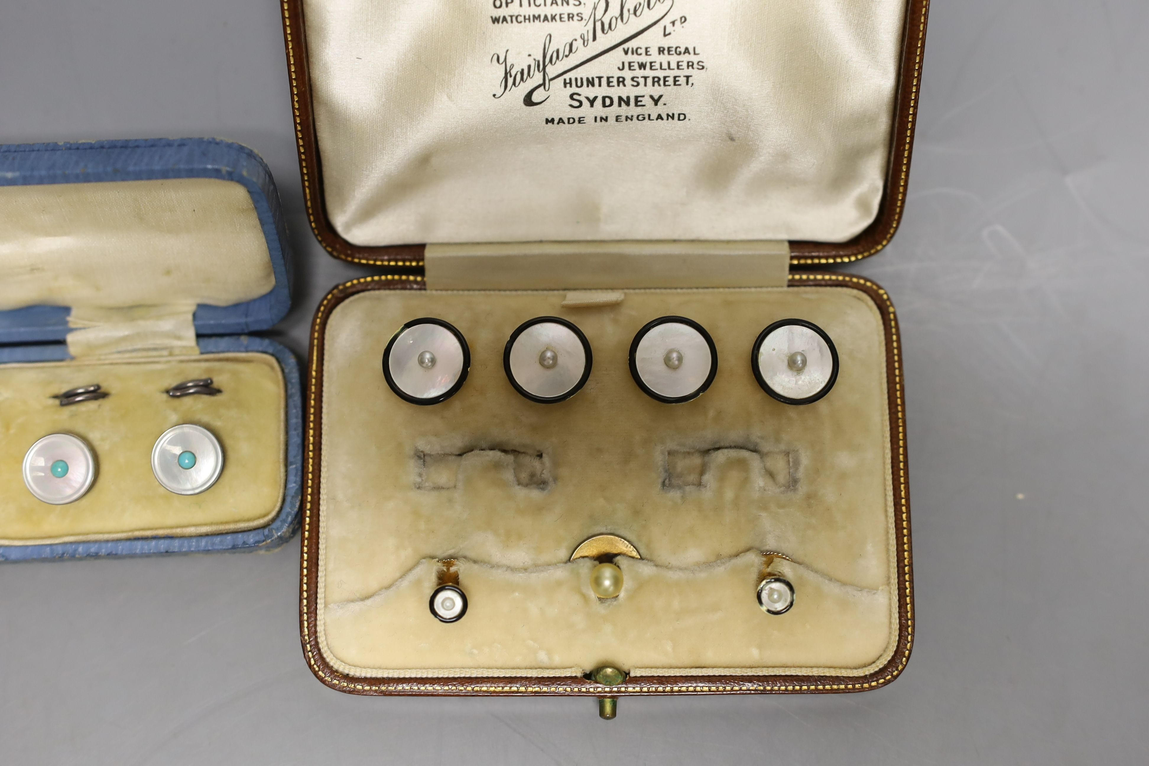 A set of four 18ct, mother of pearl, enamel and seed pearl set buttons, gross 7.2 grams, two similar 15ct studs, gross 2.3 grams and one other cased set of white metal dress studs.